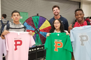 Students displaying shirts during "Spin the Wheel" Game